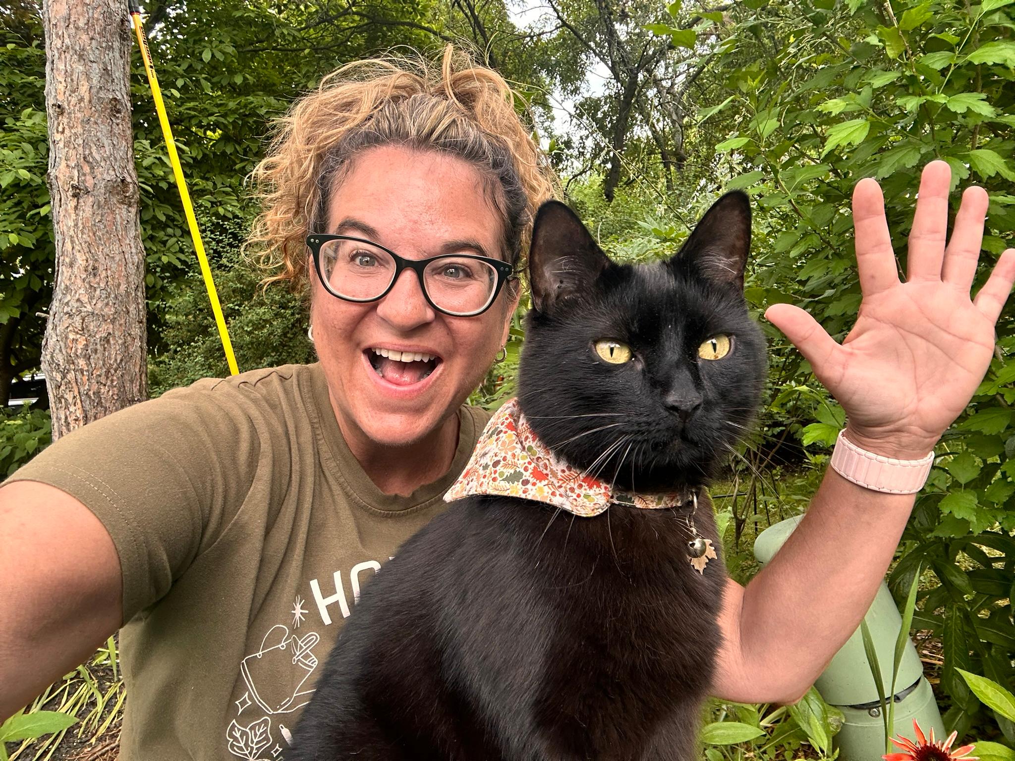 Heather in the garden with her black cat, Escalus.
