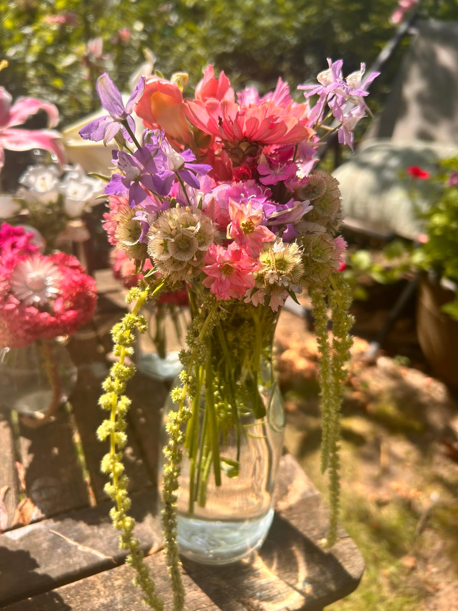 Blooming This Week bouquet with pink, purple, and white flowers arranged in a glass vase.