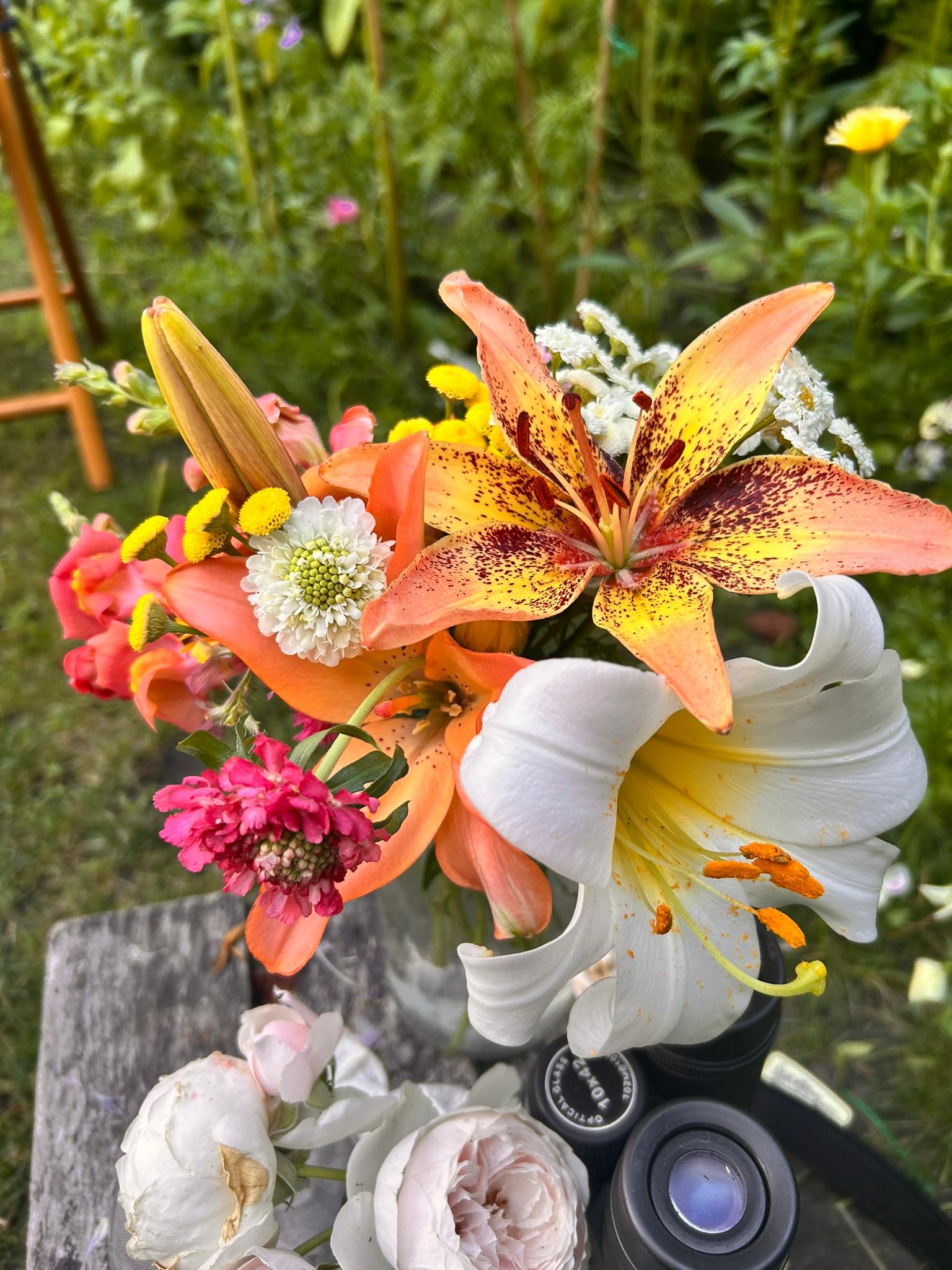Close-up bouquet with orange, white, and speckled lilies.